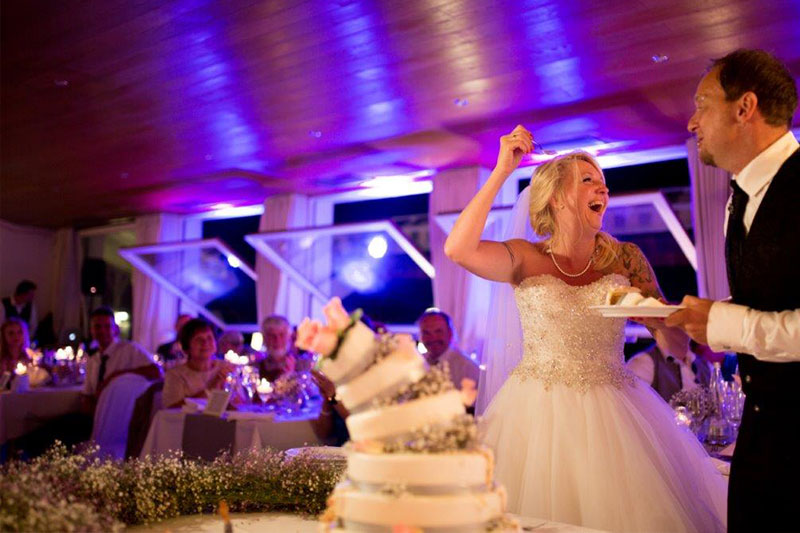 Einfach Spass haben - das beste Hochzeitsmotto ever! Braut und Bräutigam beim Anschnitt der Hochzeitstorte.